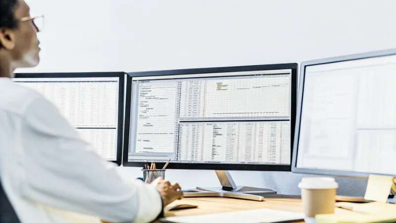 Analyst working with open-source software displaying casino game statistics and probability calculations on multiple monitors